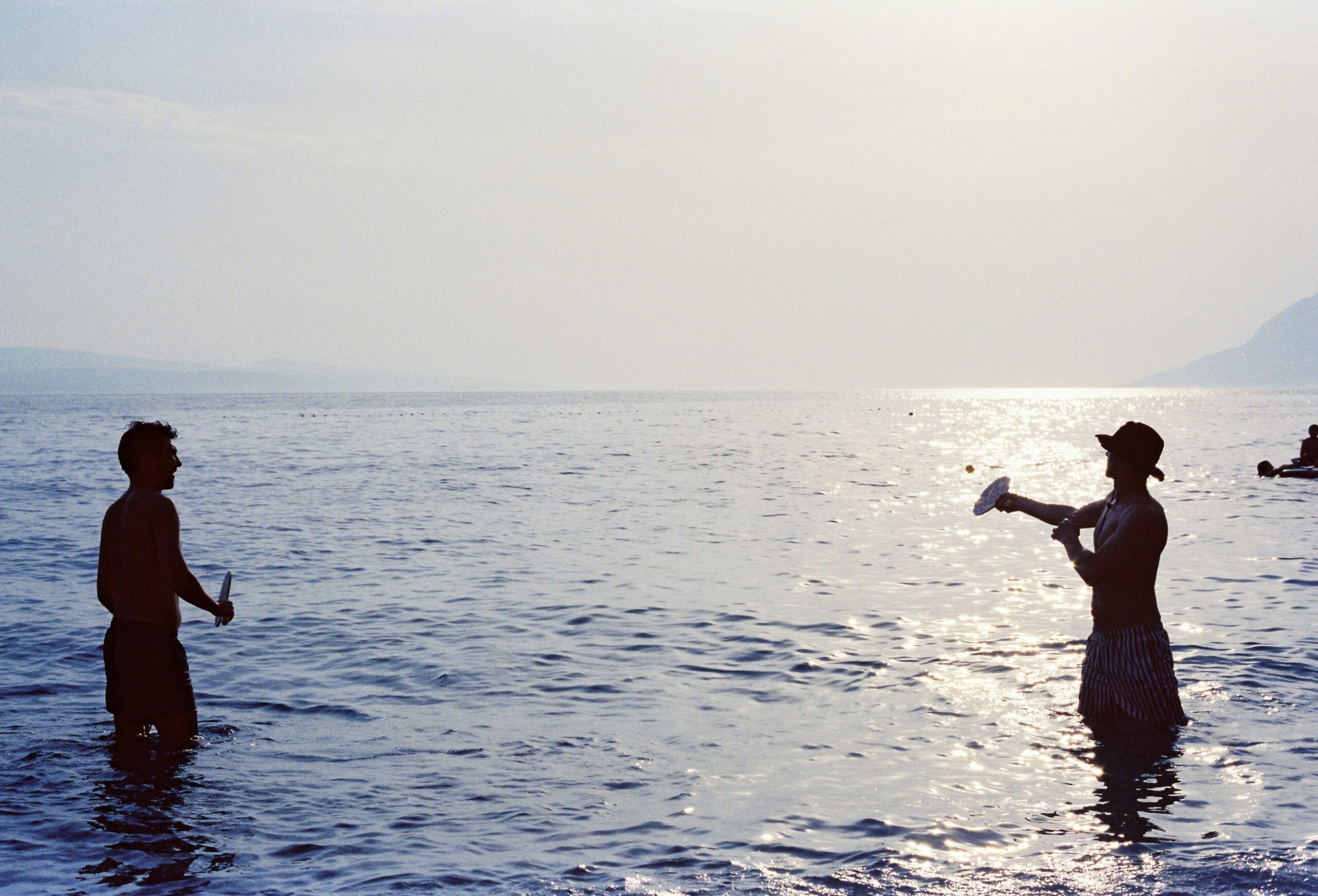 A couple of people standing in the water